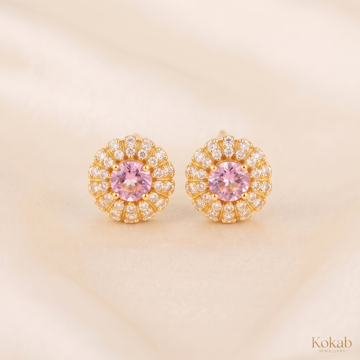 Pair of blush pink floral halo stud earrings with gold plating and cubic zirconia