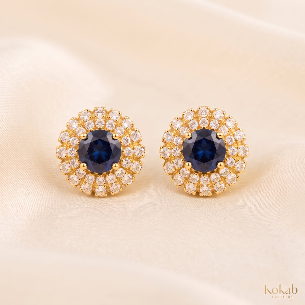 Pair of royal blue floral halo stud earrings with gold plating and cubic zirconia