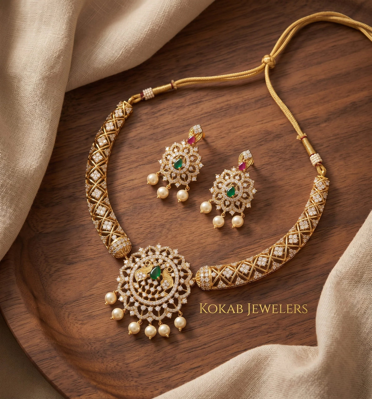 Gold plated peacock medallion necklace set with ruby emerald stones on wood