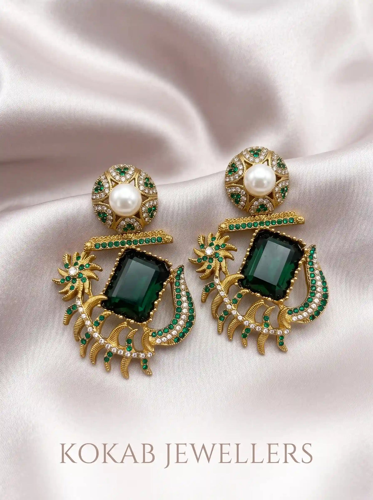 Emerald green Kashmiri statement earrings with pearl stud and white stones on silk fabric