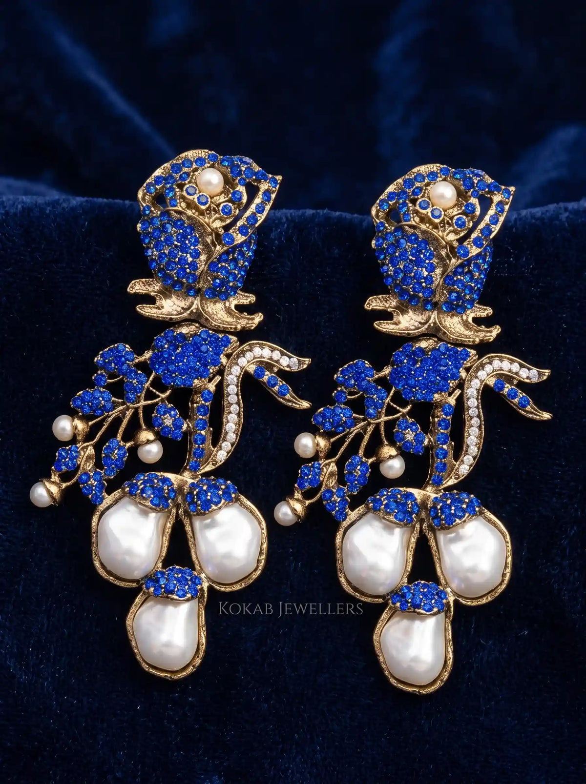 Royal blue stone rose Kashmiri earrings with large baroque pearl drops on navy velvet