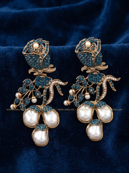 Teal blue stone rose statement earrings with baroque pearl cluster on blue velvet